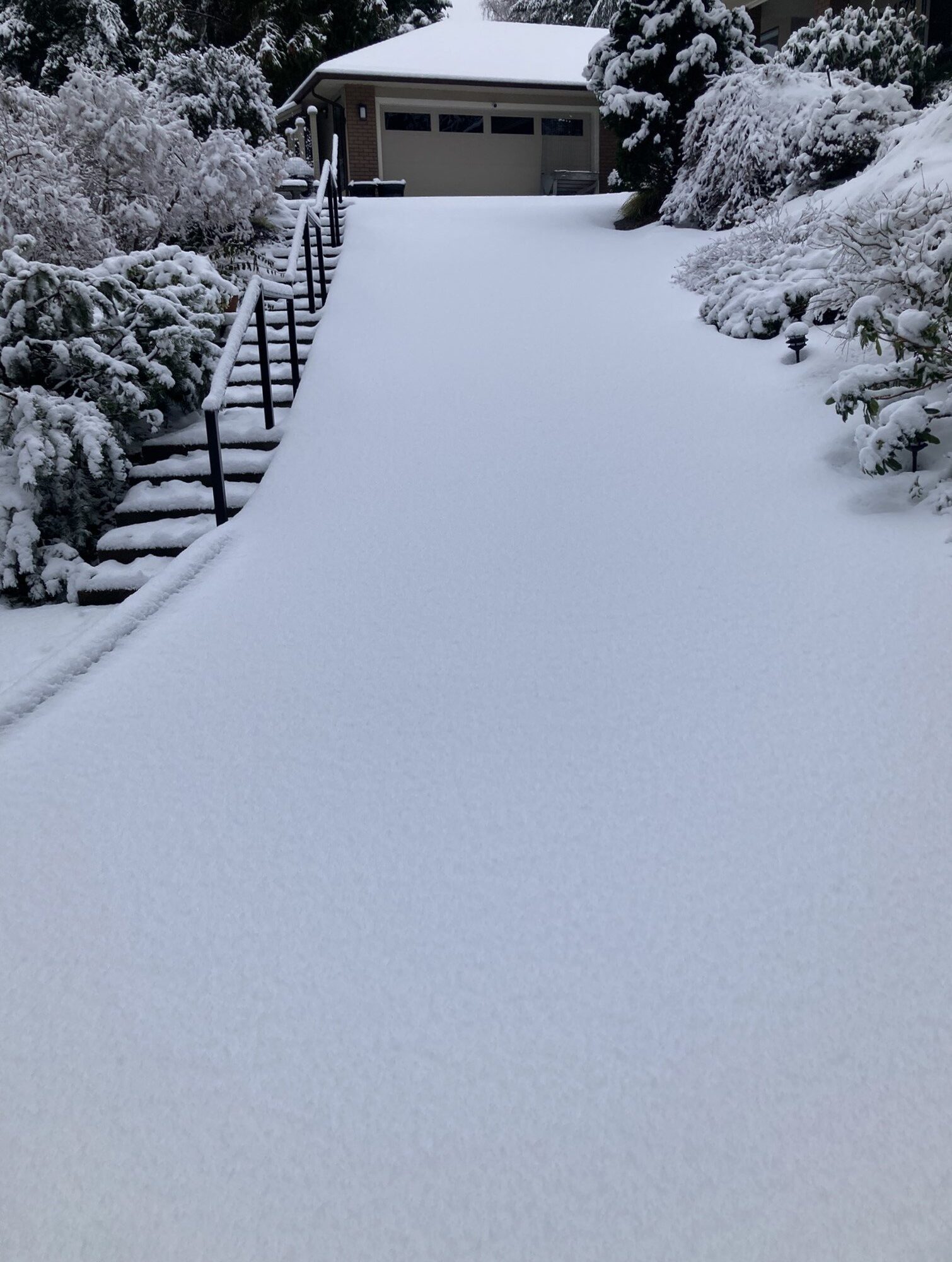 Snow covered steep driveway residential snow clearing