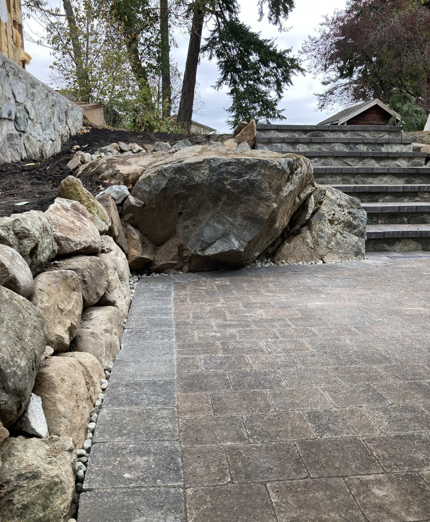 Interlocking patio and natural stone Natural stone walls and paver patio in metchosin